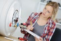 Female plumber working on central heating boiler Royalty Free Stock Photo