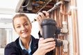 Female Plumber Working On Central Heating Boiler