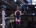 Female pole vaulter clearing the bar