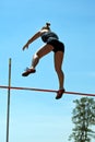 Female pole vaulter in mid-air