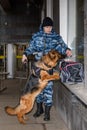 Female police officer with a trained german shepherd dog sniffs out drugs or bomb in luggage