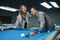 female pool player showing the phone to the male pool player