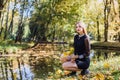 Female porteait in autumn park. Beaurtiful woman in black dress posing with yellow trees