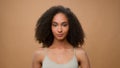 Female portrait in beige studio background attractive African American woman holding fresh avocado near face healthcare Royalty Free Stock Photo