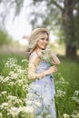 Female portrait outdoors. a woman in a straw hat in a flower field with a bouquet of wild flowers. Royalty Free Stock Photo