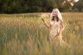 Female portrait outdoors. a woman in a straw hat in a flower field with a bouquet of wild flowers. Summer in the country Royalty Free Stock Photo