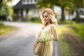 Female portrait outdoors. a woman in a straw hat in a flower field with a bouquet of wild flowers. Summer in the country Royalty Free Stock Photo