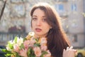 Female portrait of sensual brunette woman in yellow jacket holding a big bouquet of colorful flowers and looking at tne Royalty Free Stock Photo