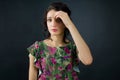 Female portrait of sensual young girl in green dress with pink flowers posing in studio on black background Royalty Free Stock Photo