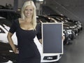 Female posing with sign in front of new cars Royalty Free Stock Photo