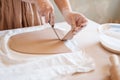 Female potter cuts clay pancake, pottery workshop Royalty Free Stock Photo