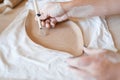 Female potter draws a pattern, pottery workshop