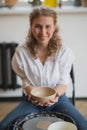 The female potter finished making a clay vase remove it from the potter`s wheel. Creating vase of white clay. Making Royalty Free Stock Photo