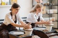 The female potters finished making a clay vase remove it from the potter`s wheel. Creating vase of white clay. Making Royalty Free Stock Photo