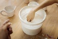 Female potter putting her hand in clay substance