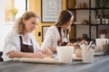 Female potter shaping piece of clay at the table. Woman making ceramic item. Pottery working, handmade and creative Royalty Free Stock Photo