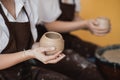 The female potters finished making a clay vase remove it from the potter`s wheel. Creating vase of white clay. Making Royalty Free Stock Photo