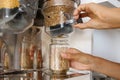 Female Pours Green Lentils from Vending Machine in a Glass Jar. Young Vegan Woman Shopping at Zero Waste Shop. No plastic