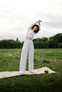 Female practicing yoga outdoor. Young sports woman retreat exercises. Asana coach hands to the slides on fresh air. Girl Royalty Free Stock Photo