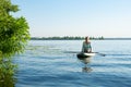 Female practicing yoga on a SUP board during sunny morning Royalty Free Stock Photo