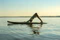 Female practicing yoga on a SUP board Royalty Free Stock Photo