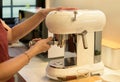 Female preparing fresh coffee while using modern coffee maker in the kitchen at home Royalty Free Stock Photo