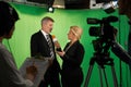 Female Presenter Interviewing In Television Studio With Crew In