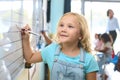Female Primary Or Elementary School Student Writing On Whiteboard In Classroom Lesson Royalty Free Stock Photo