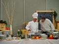 Female professional chef prepares the pasta dish at the buffet for the customer