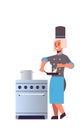 Female professional chef using frying pan stirring food woman restaurant kitchen worker in uniform standing near stove