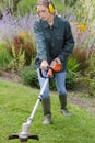 female professional gardener using strimmer Royalty Free Stock Photo