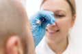 female professonal specialist is examine the eye of a male patient