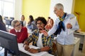 A female professor giving help to students at the informatics lecture. Smart young people study at the college. Education, college Royalty Free Stock Photo