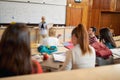 A female professor giving a lecture to students. Smart young people study at the college. Education, college, university, learning Royalty Free Stock Photo