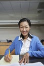 Female Professor Jotting Down Notes On Paper Royalty Free Stock Photo