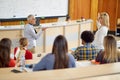 A female professor questioning students at the lecture. Smart young people study at the college. Education, college, university, Royalty Free Stock Photo