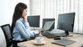 Female programmer reading document of database code to thinking for website development while using multiple Royalty Free Stock Photo