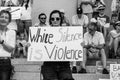 Female Protestor Holds Sign Stating White Silence is Violence