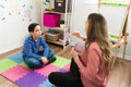 Female psychologist working with a little boy to treat his speech problem