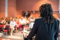 Female public speaker giving talk at Business Event. Royalty Free Stock Photo