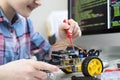 Female Pupil Building Robot Car In School Science Lesson