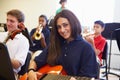 Female Pupil Playing Guitar In High School Orchestra Royalty Free Stock Photo