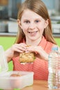 Female Pupil Sitting At Table In School Cafeteria Eating Healthy Royalty Free Stock Photo