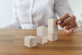 Female put wooden brick on top of another, symbol of building plans