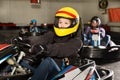 Female racer in helmet driving kart on track