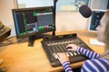 Female radio host in front of screen operating sound mixer