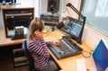 Female radio host operating sound mixer