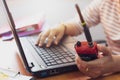 Female radio operator using Walkie - Talkie to communicate with other people and typing on laptop Royalty Free Stock Photo