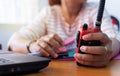 Female radio operator using Walkie - Talkie to communicate with other people and working with document Royalty Free Stock Photo