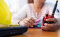 Female radio operator using Walkie - Talkie to communicate with other people and working with document